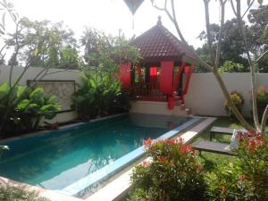 a villa with a swimming pool in a garden at Rosseno Villa in Yogyakarta