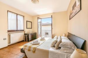 a bedroom with a large bed and a large window at Sunrise in Baveno: Apartment for 4 with Balcony - Happy Rentals in Baveno