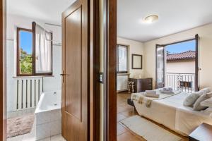 a bedroom with a bed and a bathroom with a tub at Sunrise in Baveno: Apartment for 4 with Balcony - Happy Rentals in Baveno