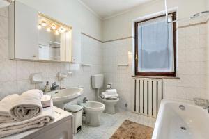a white bathroom with a sink and a toilet and a tub at Sunrise in Baveno: Apartment for 4 with Balcony - Happy Rentals in Baveno +19 photos