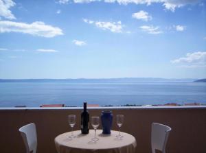 a table with a bottle of wine and wine glasses at SARITA Apartments in Makarska