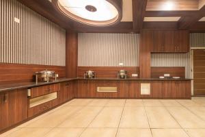 a large kitchen with wooden cabinets and a ceiling at Treebo Maple Delite in Lucknow
