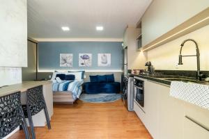 a kitchen and living room with a bed in a room at Studio c Piscina, AC e Café Novo Hamburgo in Novo Hamburgo