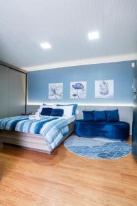 a bedroom with a bed and a blue wall at Studio c Piscina, AC e Café Novo Hamburgo in Novo Hamburgo