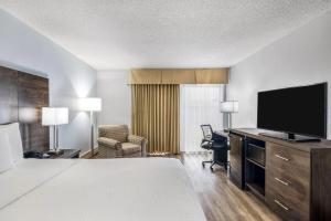 a hotel room with a bed and a flat screen tv at Days Inn by Wyndham London in London