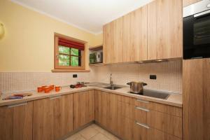 eine Küche mit Holzschränken und einer Spüle in der Unterkunft Sponda Ski in- Ski out 50m - Happy Rentals in Livigno