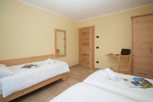 ein Schlafzimmer mit zwei Betten und einem Spiegel in der Unterkunft Sponda Ski in- Ski out 50m - Happy Rentals in Livigno