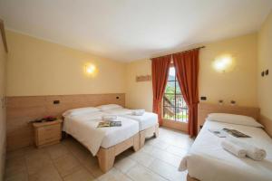 ein Hotelzimmer mit zwei Betten und einem Fenster in der Unterkunft Sponda Ski in- Ski out 50m - Happy Rentals in Livigno