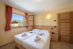 ein Schlafzimmer mit einem Bett, auf dem Handtücher liegen in der Unterkunft Sponda Ski in- Ski out 50m - Happy Rentals in Livigno + 8 Fotos