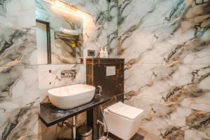a bathroom with a sink and a toilet at Travinities Hotel Shree Ji Palace in Ujjain +28 photos