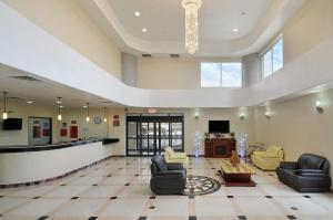 a lobby with couches and chairs and a tv at Ramada by Wyndham South Waco in Hewitt