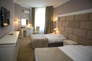 a hotel room with two beds and a desk at Kazakhstan Express in Almaty