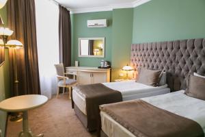 a hotel room with two beds and a desk at Kazakhstan Express in Almaty