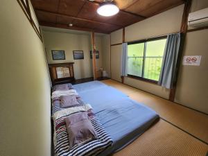 a large bed in a room with a window at Peace House Isonoura in Wakayama