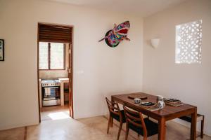 a dining room with a wooden table and chairs at Little Maua - Stylish Private Hideaway on Galu Beach in Galu