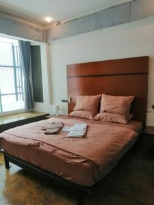 a bedroom with a large bed with two towels on it at 75 StangStay & Cafe de Art in Ka Rorn