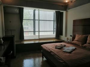 a bedroom with a large bed and a large window at 75 StangStay & Cafe de Art in Ka Rorn +9 photos