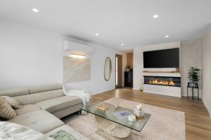 a living room with a couch and a fireplace at Mellow mountains, boutique beach house in Portarlington