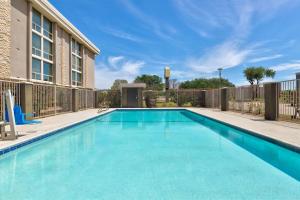 a swimming pool with blue water in front of a building at La Quinta by Wyndham Dallas I-35 Walnut Hill Ln in Oldham