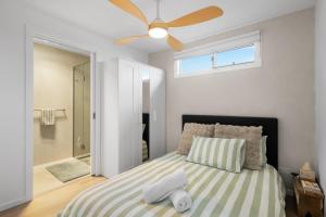 a bedroom with a bed with a ceiling fan at Mellow mountains, boutique beach house in Portarlington
