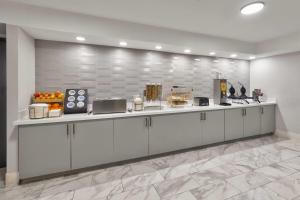 a kitchen with white cabinets and fruits on a counter at La Quinta by Wyndham Dallas I-35 Walnut Hill Ln in Oldham