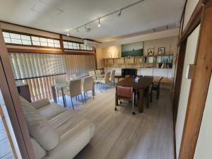a living room with a couch and a table and chairs at Peace House Isonoura in Wakayama +18 photos