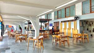 a restaurant with tables and chairs in a building at Laguna Gili in Gili Trawangan