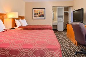 a hotel room with two beds and a flat screen tv at Econo Lodge Kennewick Tri-Cities in Kennewick