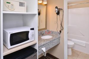 a small bathroom with a microwave and a sink at Econo Lodge Kennewick Tri-Cities in Kennewick