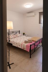 a bedroom with a bed with a pink blanket at Villa ADAM in Artemida