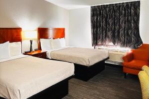 a hotel room with two beds and a chair at Quality Inn St Paul-Minneapolis-Midway in Saint Paul