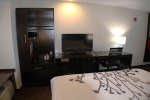a hotel room with a bed and a desk and a television at Sleep Inn Marion - Cedar Rapids in Cedar Rapids