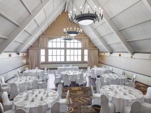 a banquet hall with white tables and chairs at Radisson Hotel Montreal Airport in Ville Saint Laurent +89 photos