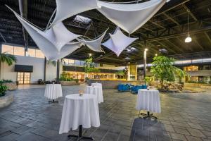 a large room with white tables and flags hanging from the ceiling at Radisson Hotel Montreal Airport in Ville Saint Laurent
