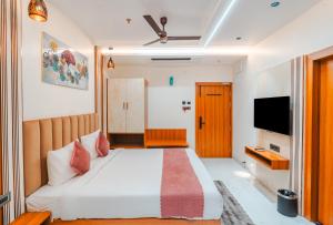a bedroom with a large bed and a television at Travinities Hotel Shree Ji Palace in Ujjain