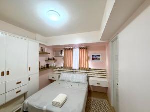 a small bedroom with a bed and a window at Centrio Tower Condo Units in Cagayan de Oro