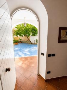 an archway leading to a pool through a door at Domus Pannella - Endless Summer in Lacco Ameno