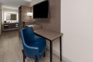 a room with a desk and a blue chair at Angel Inn Near IMAX, a Travelodge by Wyndham in Branson