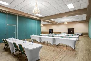 a conference room with white tables and chairs and green walls at Quality Inn & Suites in Grayling +32 photos