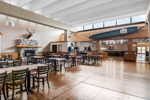 a dining room with tables and chairs and a fireplace at Quality Inn & Suites in Grayling