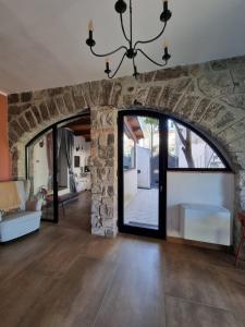 a living room with a stone wall and a chandelier at LIMO to Host in Roccaromana