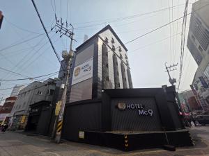 a building with a sign on it on a street at Mc9Hotel in Uijeongbu