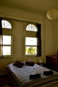 1849 Backpackers Albany في ألباني: غرفة نوم بها نافذتين وسرير