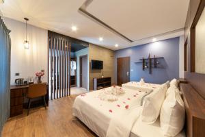 a bedroom with a large bed with a cross on the wall at LT Angkor Hotel in Phumĭ Réach Born (2) +23 photos