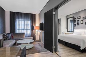 a hotel room with a bed and a couch at Protea Hotel Fire & Ice! by Marriott Pretoria Menlyn in Pretoria
