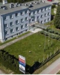 a large building with a grass field in front of it at Hortensja 309 in Koszalin