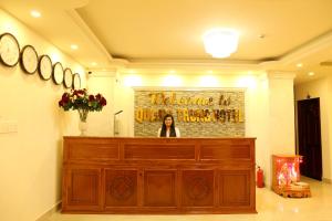 a woman is standing behind a wooden podium in a room at Quang Trung Phu Quoc Hotel in Phú Quốc