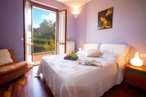 a bedroom with a white bed and a large window at Sunflower - Lake Maggiore Duplex w/ Terrace and Shared Pool in Lesa