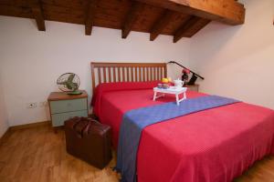 a bedroom with two beds with red sheets and a table at Sunflower - Lake Maggiore Duplex w/ Terrace and Shared Pool in Lesa