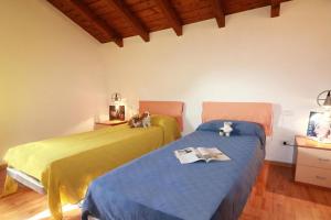 two beds sitting next to each other in a room at Sunflower - Lake Maggiore Duplex w/ Terrace and Shared Pool in Lesa +22 photos